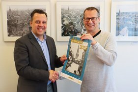 Bürgermeister Sacha Reichelt nimmt den Kalender vom z.eu.s.-Vorsitzenden Christian Lange entgegen.