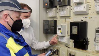 Zwei Kontrolleure vor einem Stromkasten.