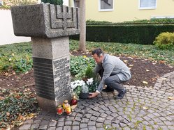 Bürgermeister Sacha Reichelt stellt eine Pflanzschale an der Gedenkstätte der jüdischen Synagoge ab