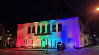 Das Alte Rathaus angeleuchtet in Regenbogenfarben.