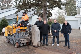 Vertreter von Stadt, Dorfgemeinschaft und Telekom mit der Maschine, die die Glasfaserkabel in Schweinheim einzieht.