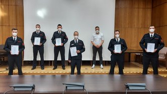 Bürgermeister Sacha Reichelt mit sechs Feuerwehrmännern bei der Urkundenübergabe