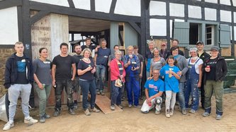 Ein große Gruppe Helfer vor dem betroffenen Fachwerkhaus in Schweinheim.